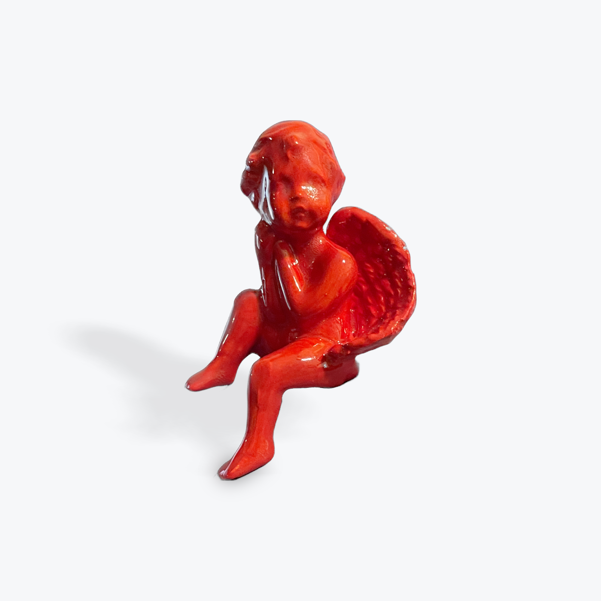 Cherub glazed entirely Red, sitting.